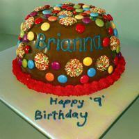 Pinata Cake Chocolate cake with buttercream and lots of candy then covered with chocolate shell decorated with smarties and freckles!!