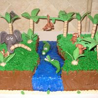Fun In The Jungle This cake has a hand carved river with fondant aligators. The gumpaste monkeys are trying to cross the river and they have enlisted the...