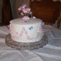 Virginia White fondant covered cake with pink and lavender flowers and butterflies formed from gum paste
