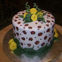 Leopard And Yellow Roses Leopard print painted fondant with yellow ribbon roses.