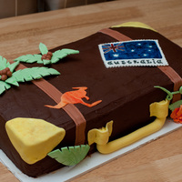 Bon Voyage Luggage Cake Cookies and Cream cake iced in chocolate BC, with fondant suitcase accents and gum paste palm fronds and flag "sticker". Made for...