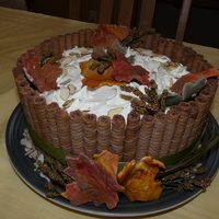 A Thanksgiving Dessert Poppyseed Chiffon Cake with vanilla almond and blueberry filling. Decorated with Pirouette style cookies and gum paste maple leaves, ribbon...