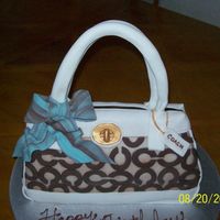 Coach Purse Cake This was a birthday cake made to look like a Coach Purse, the handle, bow and chain are all made from fondant.