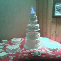 Heart Themed Wedding This is a buttercream wedding cake, with four heart satellite cakes. Each cake was a different flavor. The pink hearts on the swags matched...