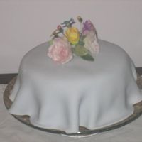 Tablecloth Cake This cake is covered in pale blue fondant with a spray of different gumpaste flowers