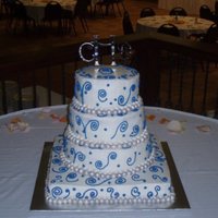 Blue Spiral Wedding Cake This cake was done in mostly buttercream frosting. I did use fondant for the ball border and then painted them with silver luster dust.