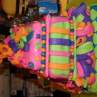 Mad Hatter Topsy Turvy Cake Four layers angle-cut square cakes in graduated sizes, covered in fondant with whimsical decor.