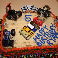 Monster Jam Truck Cake cake iced in buttercream and topped with graham cracker crumbs (to look like dirt). used left-over cake to make hills for cars to be...