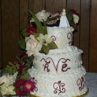 Vincent Wedding 3 tier yellow and chocolate cake with buttercream icicng and freehanded scroll work.Flowers are silk.