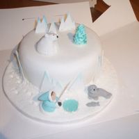 Polar Bear/ Eskimo Christmas Cake Large round fruit cake with white sugarpaste and magic sparkles coating with icing models of polar bear, seal and eskimo plus pond