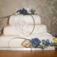 Swag Wedding Cake Square gold silver and blue wedding cake with swag and flower spray