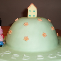 Peppa Pig Hill Peppa Pig's hill and her little house. The cake is sponge filled with chocolate buttercream.