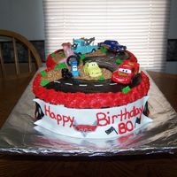Disney Cars Fondant covered cake with fondant decorations. Characters are store bought figurines. This cake had to travel 5 hours to another state.