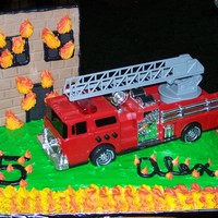Fire Truck Cake Fire truck cake with flame border. The truck was a toy that the mother bought so the little boy could keep it. The building is made of...