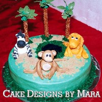 Jungle/zoo Cake I made this cake for a 1st birthday. Iced in Buttercream, piping gel pond & gumpaste animals. The plam trees are pretzels w/ royal...