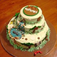 Jungle Theme Baby Shower Cake Three tiers of white cake with a soft green cream cheese buttercream decorated with gumpaste & fondant animals, trees and other...