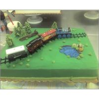 Train Set Cake Yellow sheet cake with buttercream frosting. Wooden train set provided by parent. One of my earlier cakes.