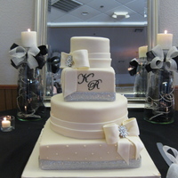 "krissy" Bride wanted me to replicate a Pink cake box cake. 4 tier ivory fondant with bling band, fondant bows and bling broaches. Entire cake was...