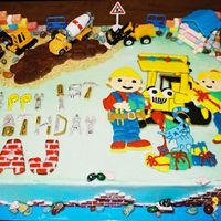 Bob The Builder Bob the Builder cake iced in buttercream. Colorflow letters and plaque. Fondant road, brick sides and letters. Candy legos, rocks and logs...