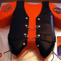 Harley Leather Vest Two layer 1/2 sheet cake iced in buttercream. Vest is chocolate fondant. Laces, buttons, chains and decals are all gumpaste.