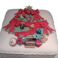 Decorated Christmas Tree Cake Fruit cake with marzipan layer finished with sugarpaste layer and decorations.