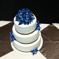 Tropical gumpaste flowers colored to look like a blue dendrodium orchid.