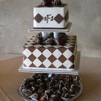 Ivory And Chocolate Checkerboard Iced in BC, decorated with fondant cut-outs. Garnished with chocolate covered strawberries.