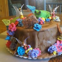 Fairy Tree Stump Cake Tons of fun to make!! Stacked some rounds, covered in fondant, added fondant accents as well as plastic fairies. The little wooden sign...