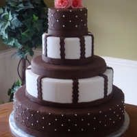 Brown And White Wedding Cake This cake was a lot of fun! Covered in chocolate fondant and white fondant with the royal icing details and topped with peach roses.