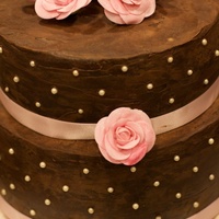 Engagement Cake Chocolate cake both covered in chocolate ganache. Draggies added with pink ribbon. Roses are made out of gumpaste.