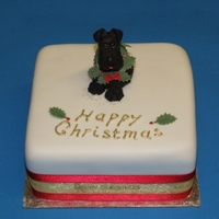 Mini Christmas Cake With Mini-Schnauzer Fondant covered mini fruit cake. Topper dog and wreath from sugar paste.