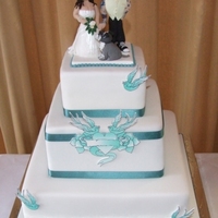 Tattoo Wedding Cake With Hand Modelled Toppers Fruit, chocolate and sponge tiers covered with fondant. Tatto is an edible image mounted onto gumpaste and cut out (fiddly!) The bride and...