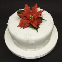 Poinsettia Christmas Cake Fondant covered fruit cake with snowflakes and poinsettia made from sugar paste.