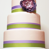 Pink Wedding Cake With Purple Gumpaste Flower Accented with green and purple grosgrain ribbons