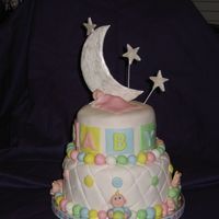 Sweet Dreams For Baby! This stacked cake is covered in quilted white fondant and enhanced in pastel colors. Five fondant babies enhance all sides and the top of...