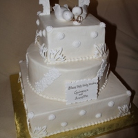 White On Ivory Wedding Almond cake with orange buttercream, red velvet with cream cheese cakes. Ivory buttercream with white fondant accents. All edible except...