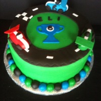 Race Car Birthday Cake For a 6th birthday. Deep Chocolate cake filled with Cookies N Cream icing, covered in MMF. Race cars in gumpaste.