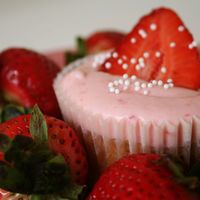 Strawberry Daiquiri Cupcake Cupcakes with strawberry puree, lime zest, rum syrup, strawberry frosting. Topped with sliced strawberry and nonpareils.