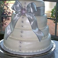 Fondant W/ribbon Wedding Cake This was our first wedding cake. Marshmallow fondant and royal icing border. The 'buttons' down the front are made from royal...