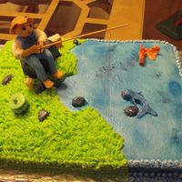 Fisherman's Birthday this is a carrot cake with cream cheese icing. fondant fisherman and fish, rocks, etc..