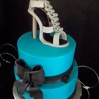Teal And Black Cake With Gucci Heel Topper 10" round and 8" round iced in buttercream with gumpaste ribbon, bow and gucci high heel.