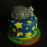 Toy Story Birthday Cake Half ball pan moon on top of an 8" round, covered in fondant. The red ribbon matched the candles that were later placed on the cake -...