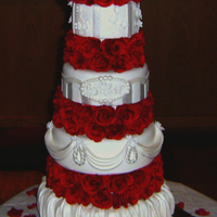 White Wedding Cake With Red Roses I used white fondant to both cover the cakes and for the decorations. The red roses between the tiers are silk. I used both pearl luster...