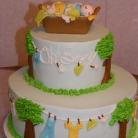 Clothes Line Cake Iced in buttercream with fondant baby clothes. Basket is made of fondant/gumpaste. TFL