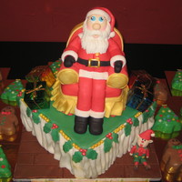 St Nick I just did this cake just last weekend for a company party. It is 40 mini cakes with Santa made out of fondant and gumpaste his belly is...