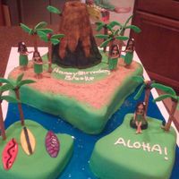 Hawaiian Island Cake Chocolate cake, buttercream, and MMF cake. Hulu girls, palm trees, parrots and surf boards all MMF. Poured sugar for the ocean, crushed...