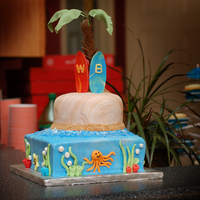 Beach Theme Birthday Cake Fondant covered cake with Fondant Palm Tree and surf boards. All decorations made out of fondant.