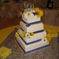 Wedding Cake This wedding cake is all buttercreme with a fondant ribbon around the bottom. The flowers are all fresh flowers picked out by the bride.