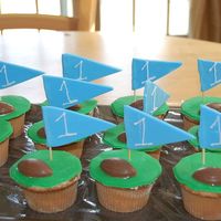 Dsc_0294.jpg these are yellow cupcakes covered in green fondant, pennant is also fondant and #1 is for the first birthday boy :) chocolate footballs on...