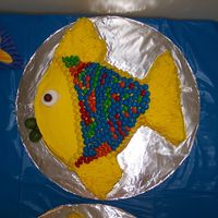 Gotta Love Fishes Tropicsl fish cake decorated with a Whopper for an eye, lollipops for lips and M&M's for scales.